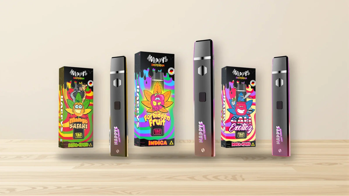 Packungen und Vapes von Happys Amsterdam auf hellem Eichenholz, Titelbild zu Happys Amsterdam Erfahrungen